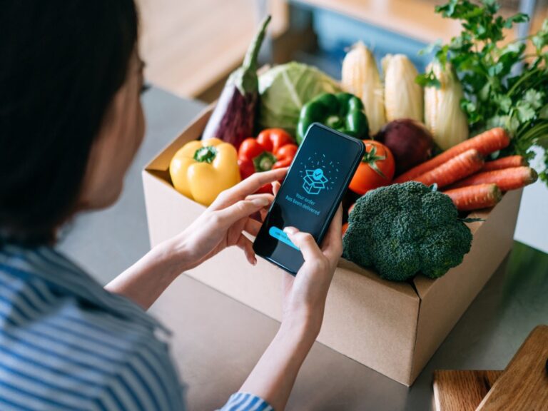 over-the-shoulder-view-of-young-asian-woman-doing-home-delivery-grocery-shopping-online-with Court Dismisses Instacart IPO Securities Suit
